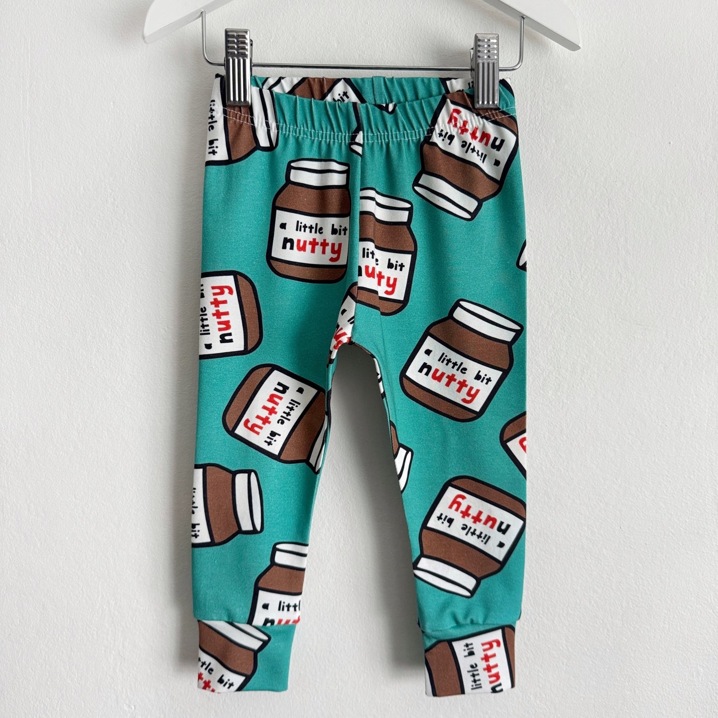 Teal coloured leggings with jars of chocolate spread on them with the phrase "a little bit nutty"