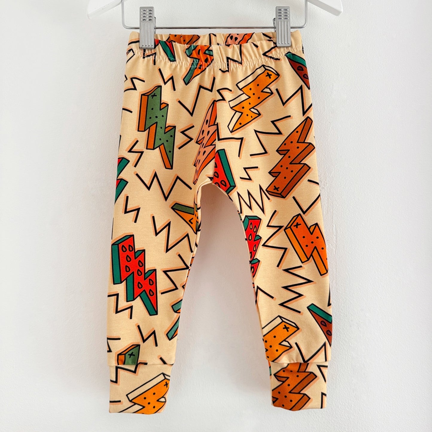 Cream leggings with neutral toned lightning bolts and zig zags on.