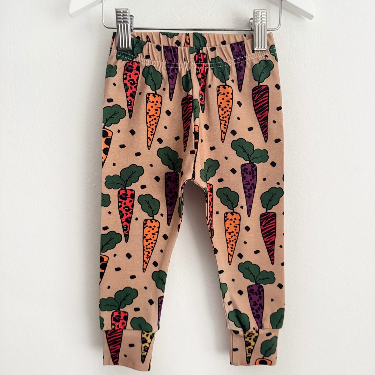 beige coloured leggings with brightly coloured carrots on them. The carrots have animal prints on them.