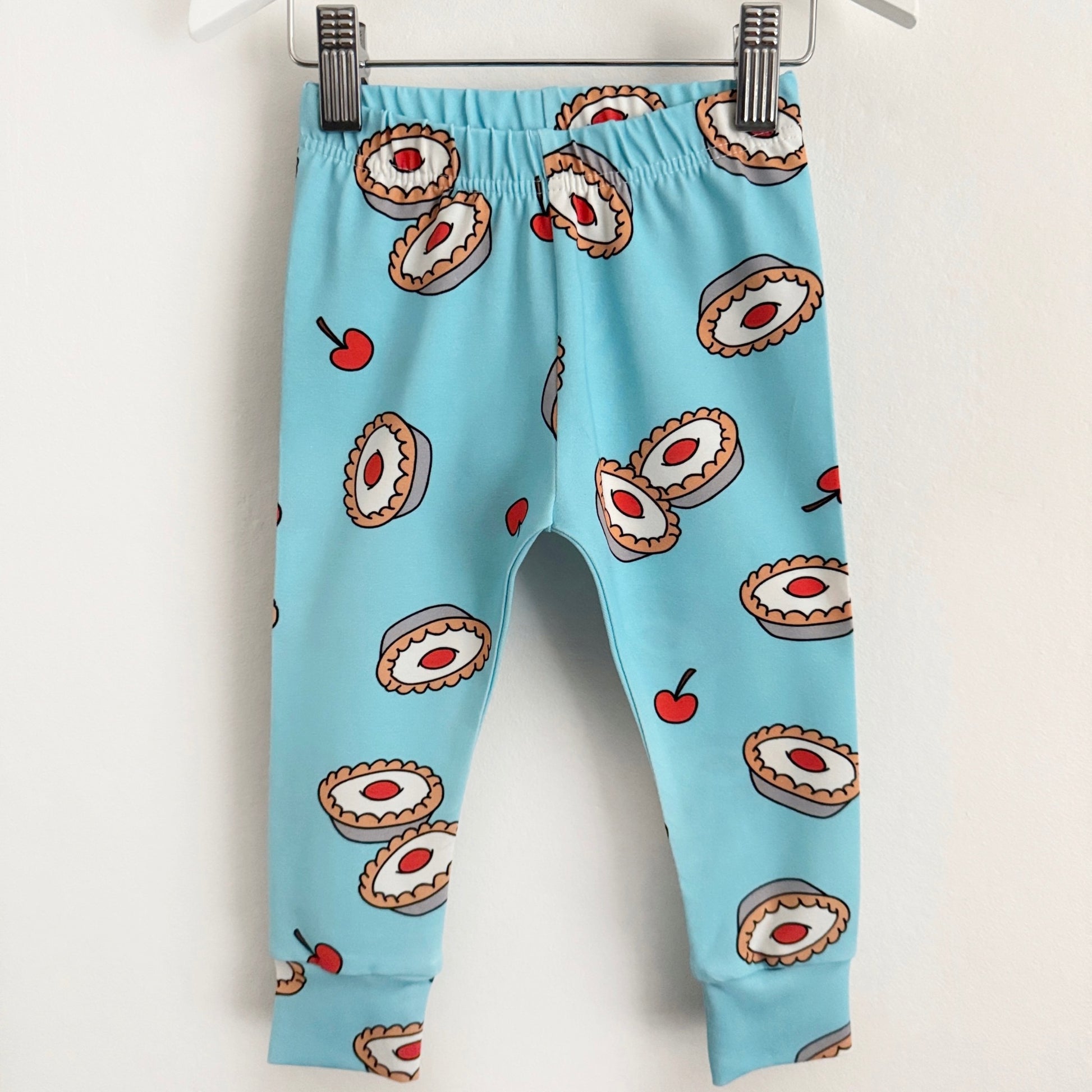 Light blue leggings with cherry bakewell cakes and cherries on them.